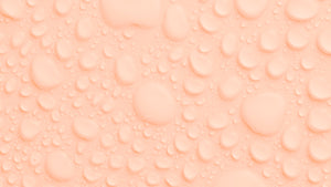 This photo includes beads of water pooled on a peach backdrop.